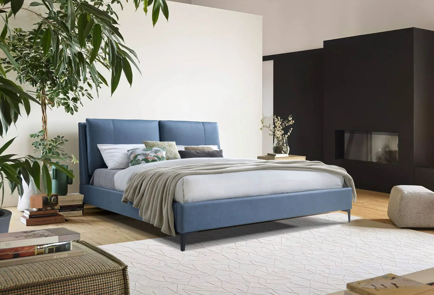 Fully upholstered blue bed with tall headboard and layered linen bedding in a modern minimalist bedroom Unique Piece Furniture on Tampa Home & Garden Store