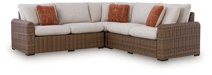 Dolan Creek Outdoor Sectional; brown wicker frame with beige cushions and orange pillows on Tampa Home & Garden Store