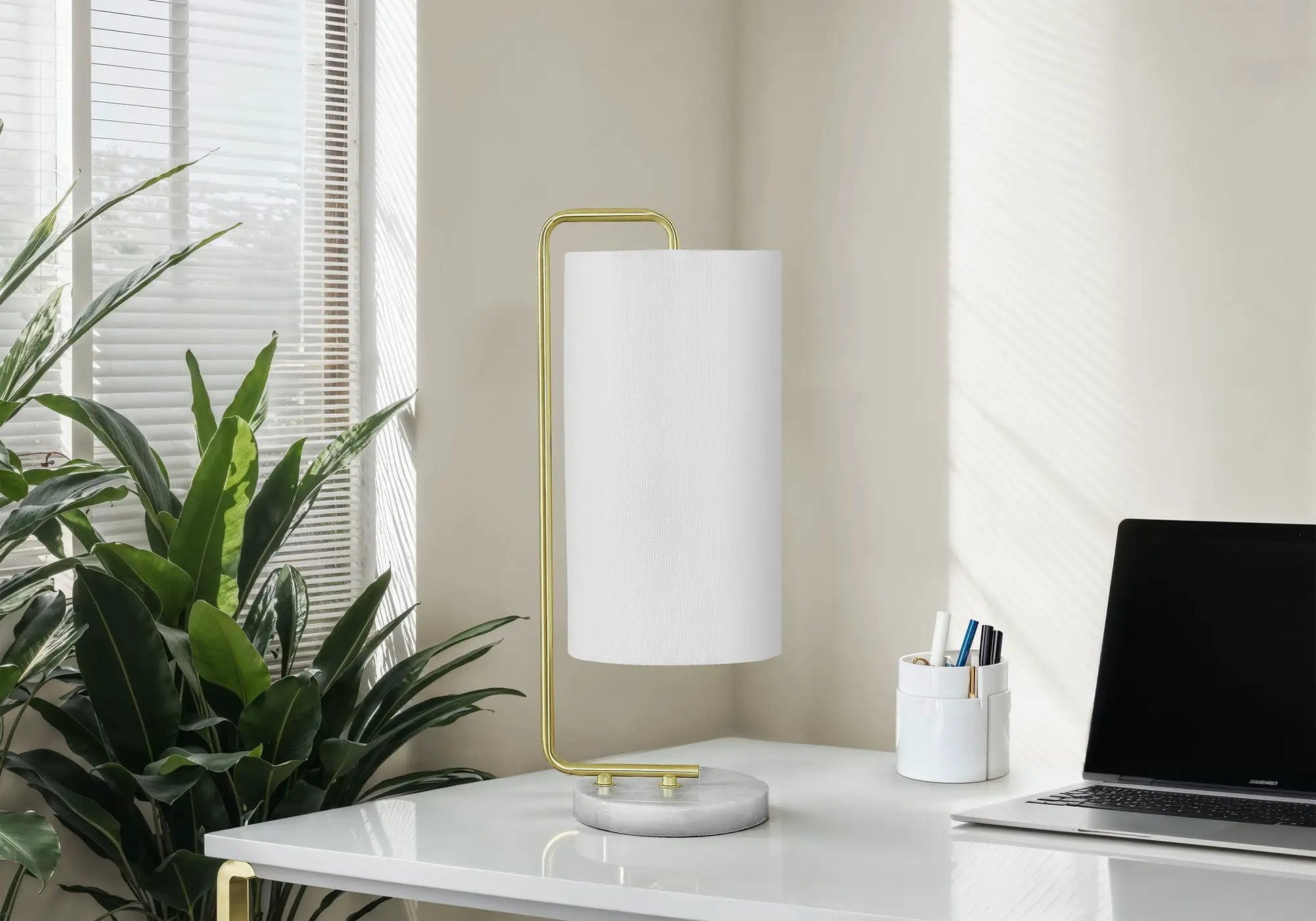 Table lamp with white fabric shade and gold curved frame on marble base on Tampa Home & Garden Store