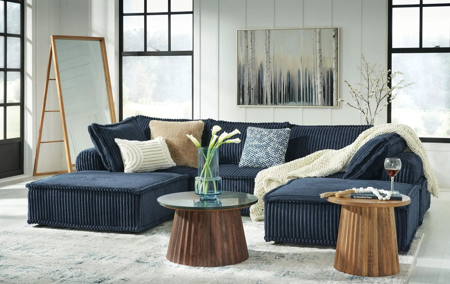 Bales Sectional navy blue corduroy with ottoman and cream knit throw in bright living room on Tampa Home & Garden Store