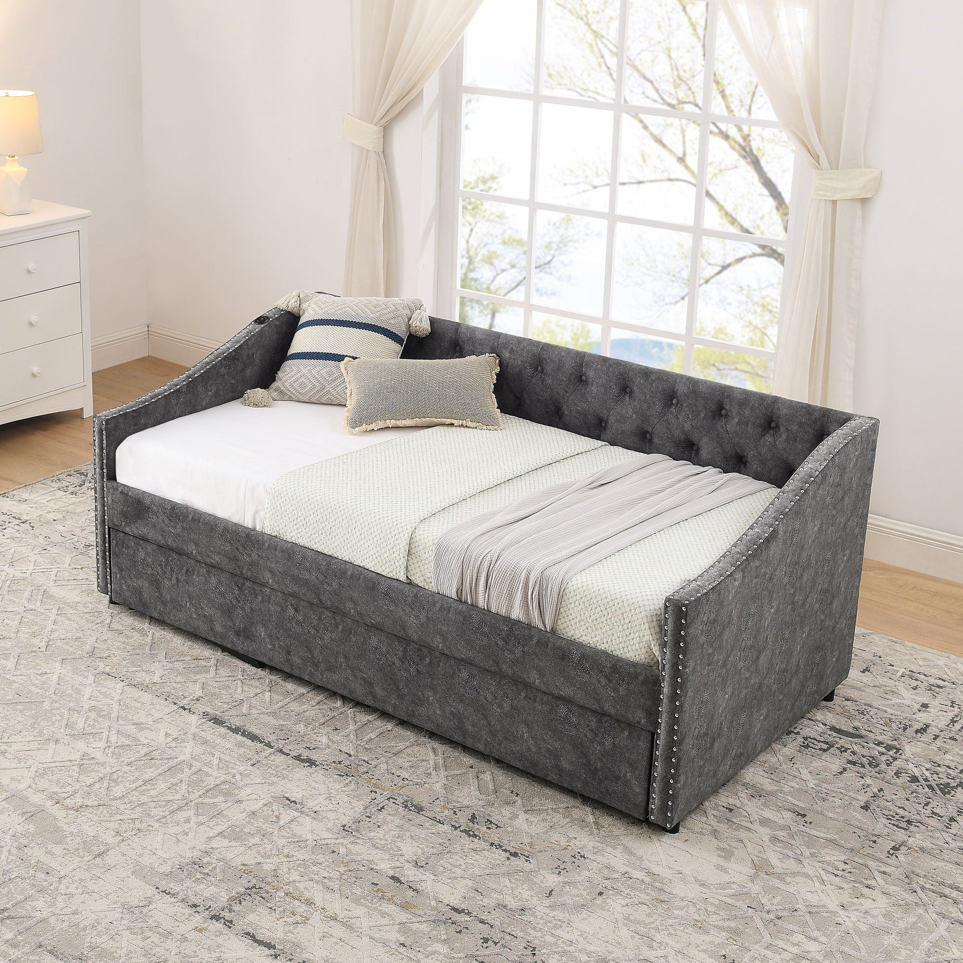 Upholstered Daybed with USB charging and pull-out bed in charcoal gray with studded trim on Tampa Home & Garden Store