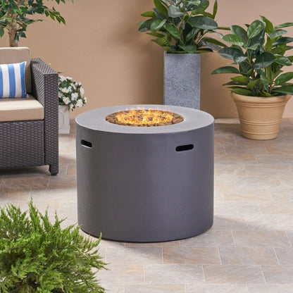 Round iron fire pit with 40,000 Btu flame and lava rocks on a patio with greenery on Tampa Home & Garden Store
