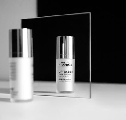 Two Filorga Lift-Designer face serum bottles with silver caps reflected in a mirror on white surface on Tampa Home & Garden Store
