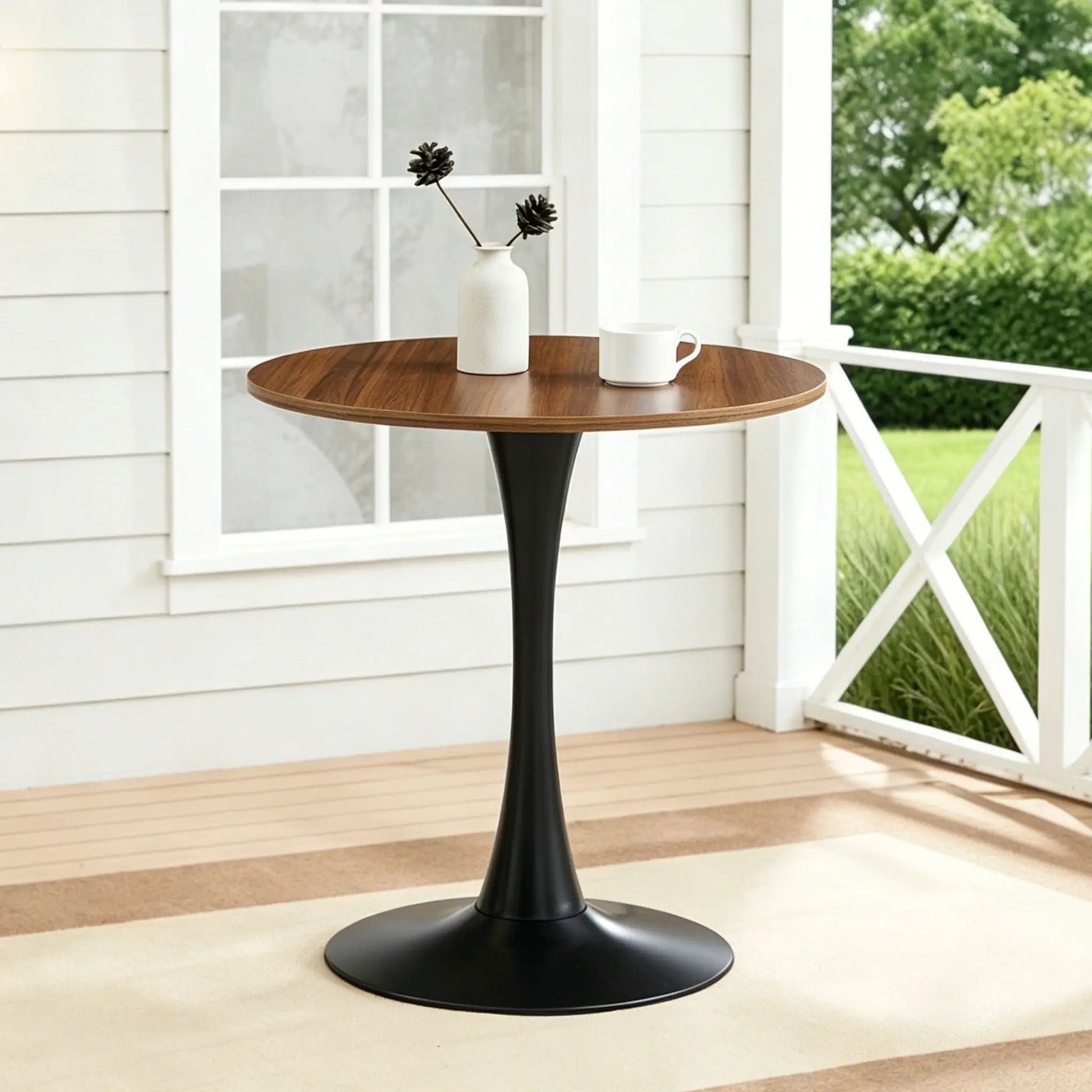 Round dining table with tulip-style black pedestal base and warm walnut wood top on Tampa Home & Garden Store