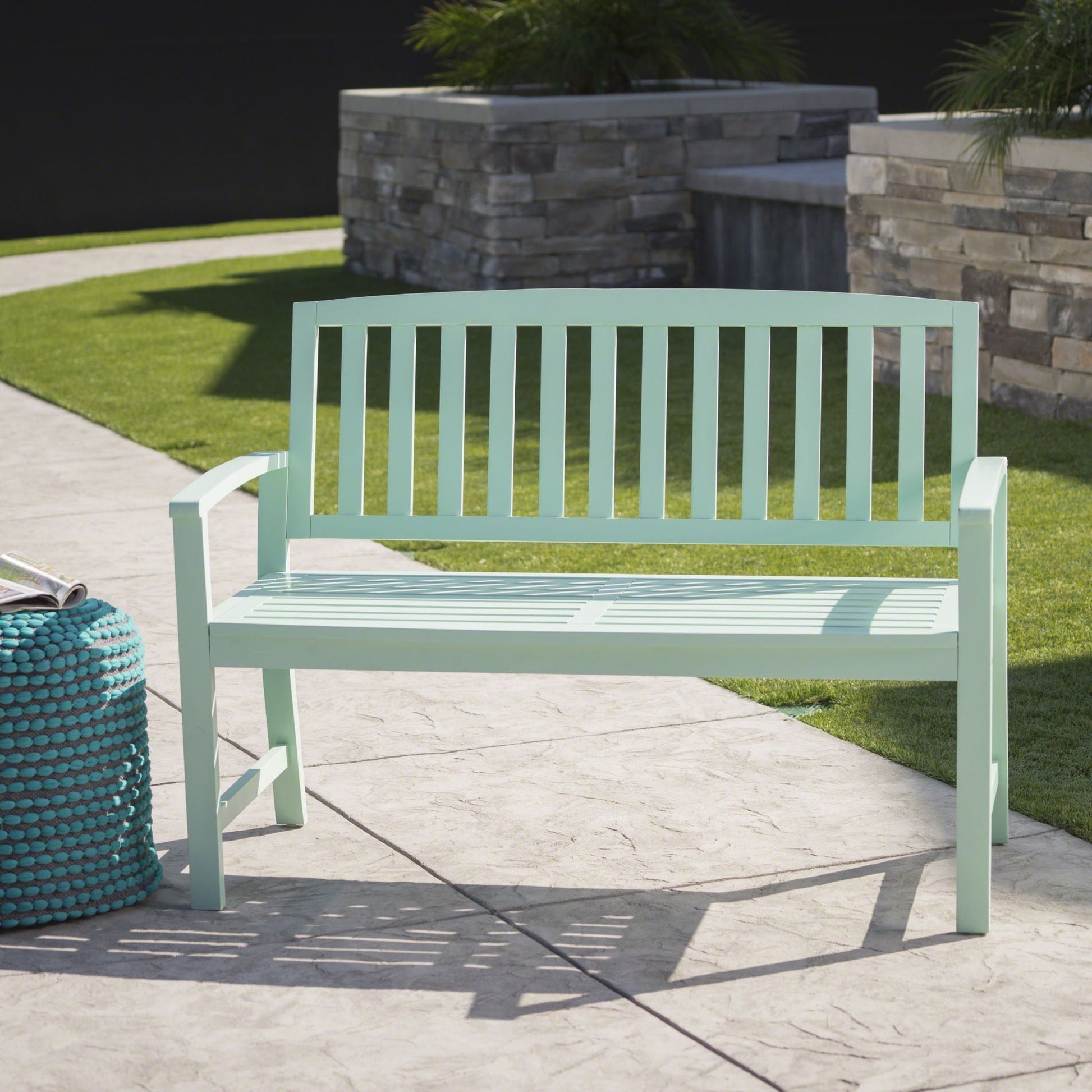 Mint green wooden Loja outdoor bench with slatted back on a stone planter backdrop on Tampa Home & Garden Store