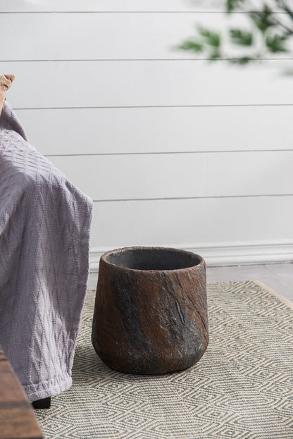 Cement planter by HouseOfZazla in brown finish on a woven rug beside a gray throw on Tampa Home & Garden Store