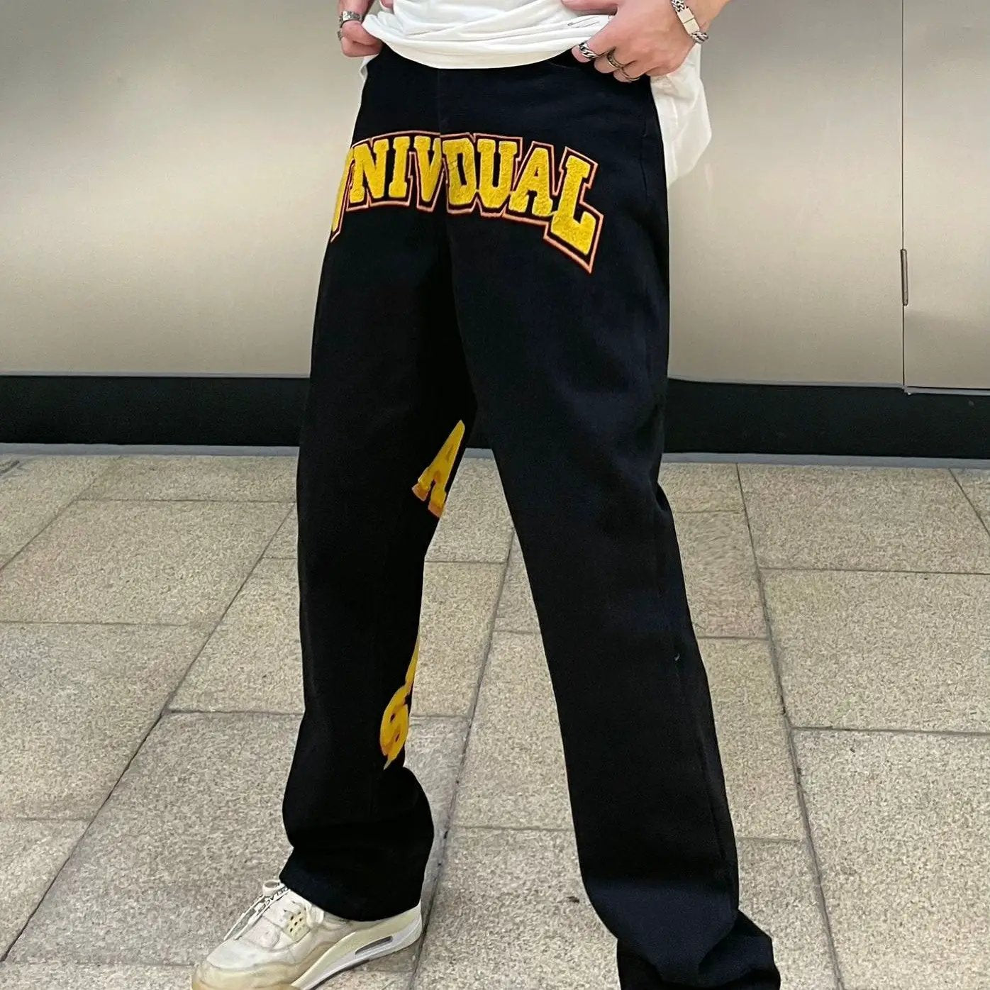 Black street-fashion jeans with bold yellow INDIVIDUAL embroidery on thigh by FLIPSTYLEZLLC on Tampa Home & Garden Store
