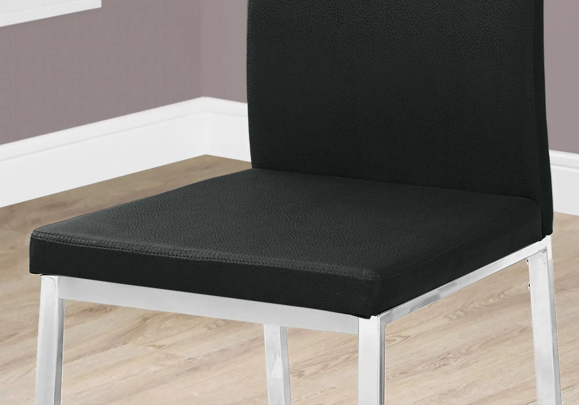 Dining side chair upholstered in black textured faux leather with chrome metal legs on Tampa Home & Garden Store