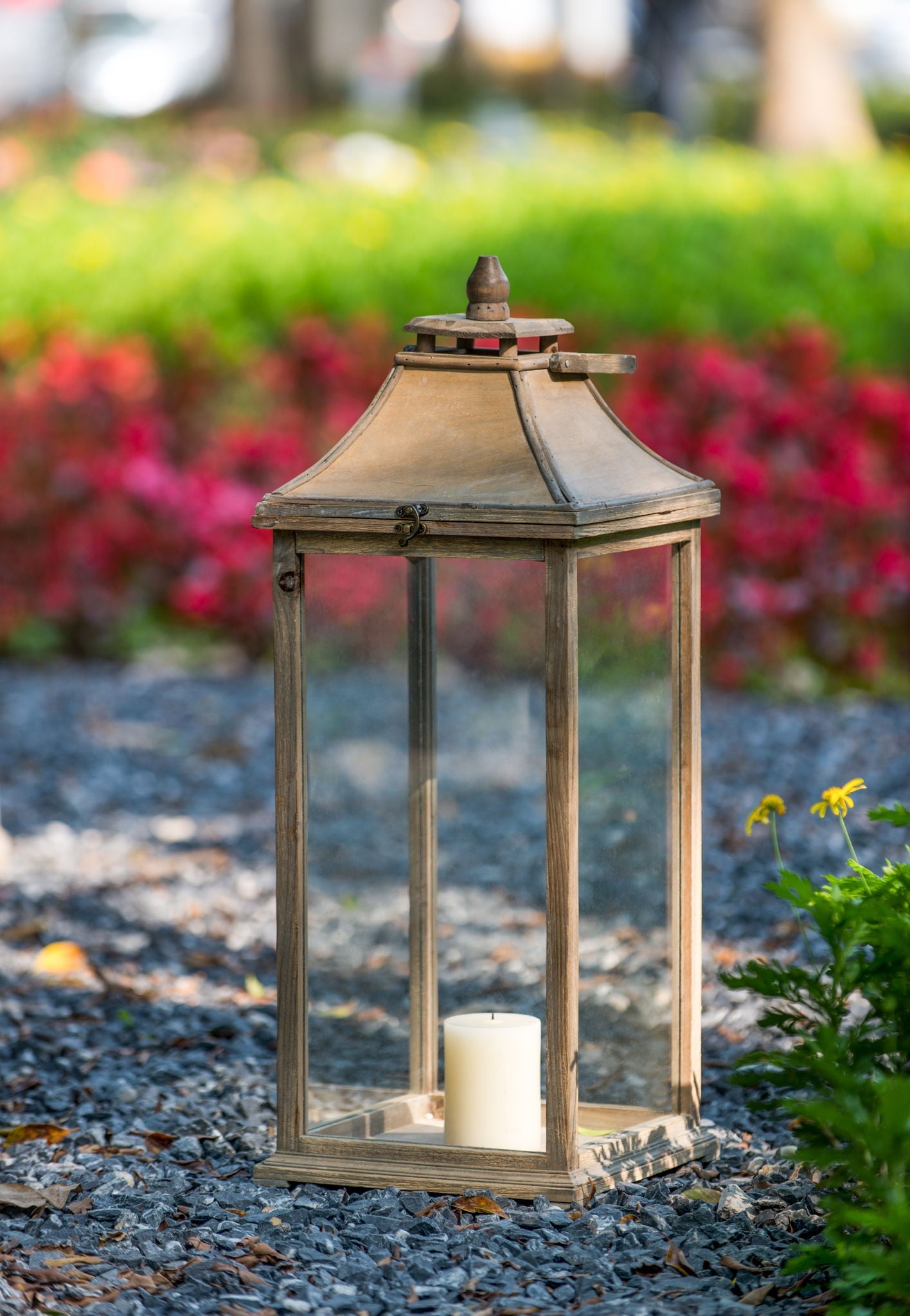Ivory wood hurricane lantern with glass panels and candle inside on garden gravel on Tampa Home & Garden Store