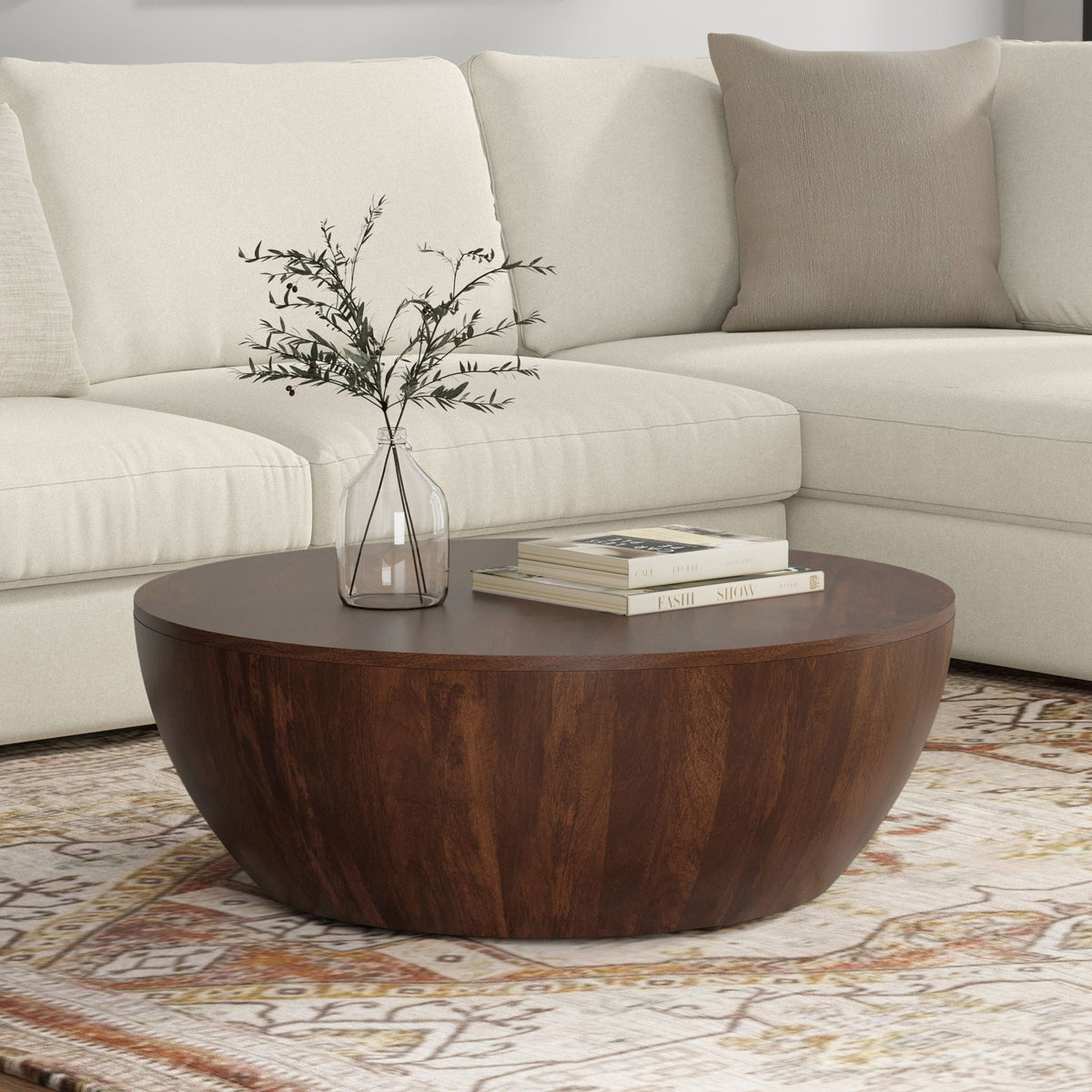 Elmbrook Drum Coffee Table round dark wood with vase centerpiece on beige sofa on Tampa Home & Garden Store
