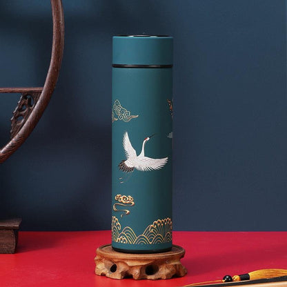 Teal stainless steel thermos bottle with white crane and gold wave motif, black lid on Tampa Home & Garden Store