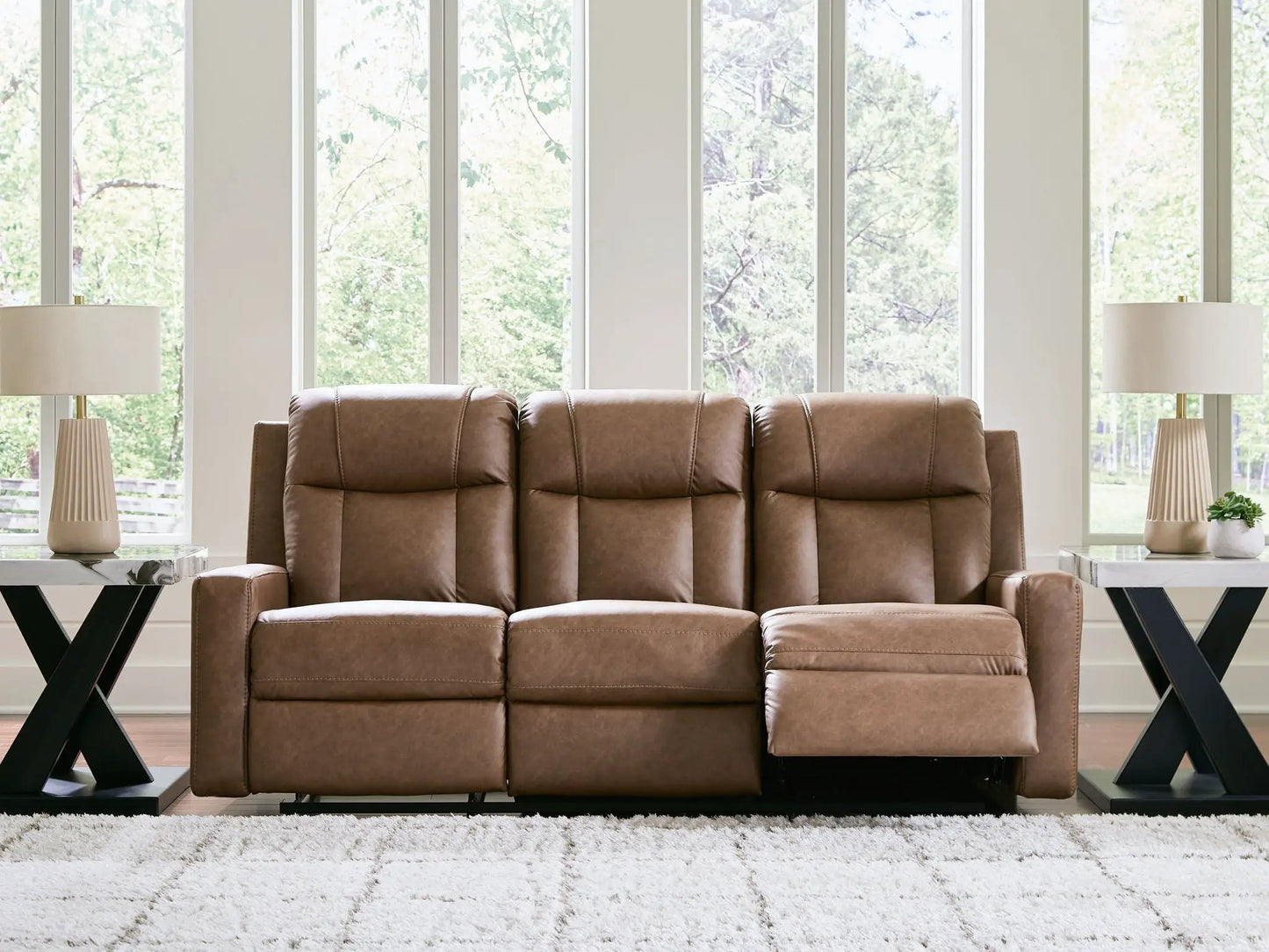 Mackmenville reclining sofa, brown leather by Unique Piece Furniture, in a bright living room on Tampa Home & Garden Store