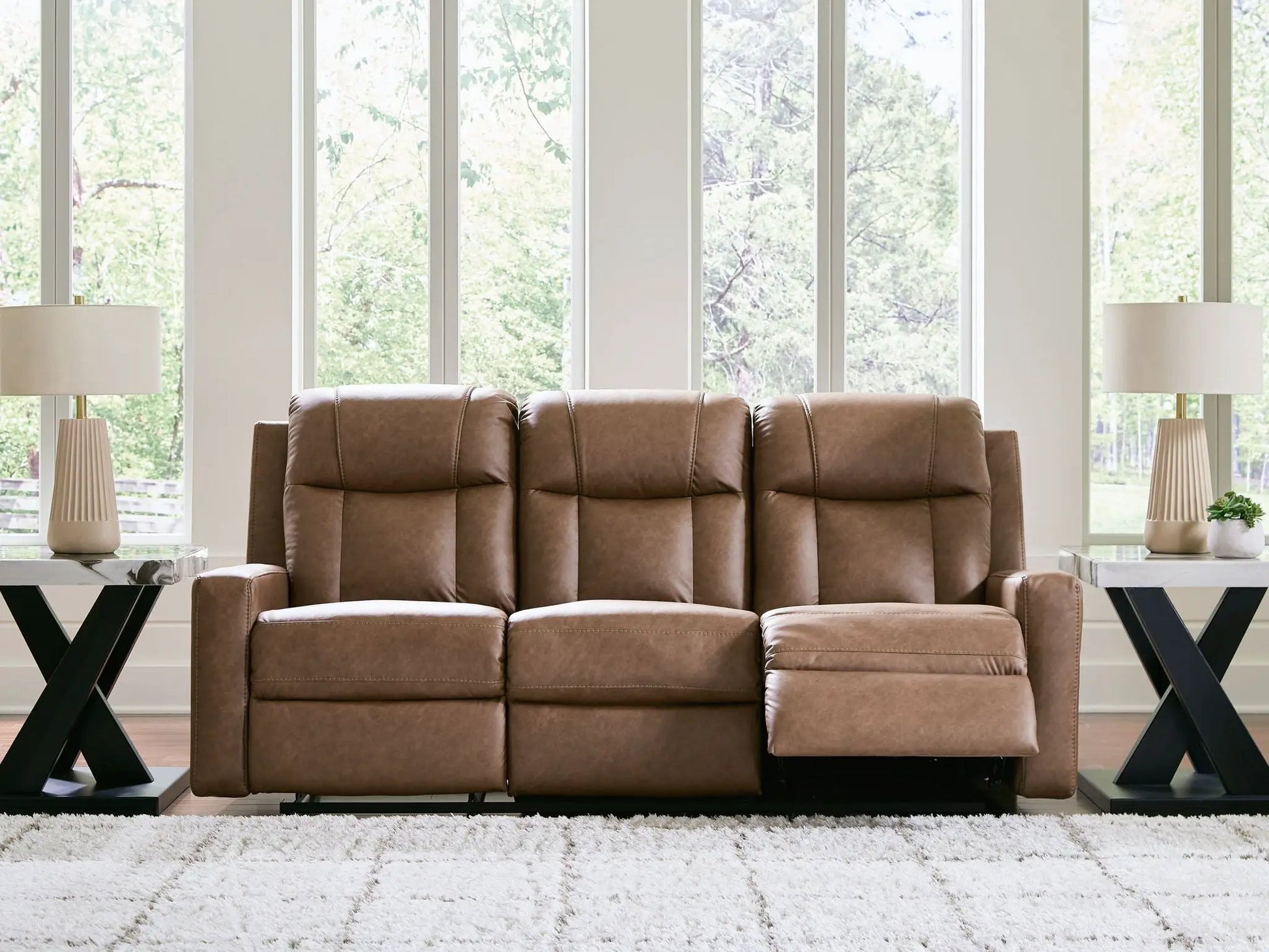 Mackmenville reclining sofa, brown leather by Unique Piece Furniture, in a bright living room on Tampa Home & Garden Store