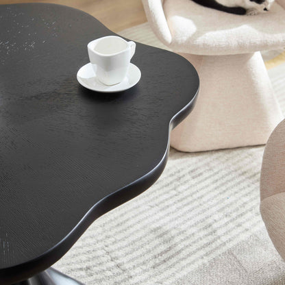 Sculptural round black dining table with textured wood grain surface, white cup and saucer on Tampa Home & Garden Store
