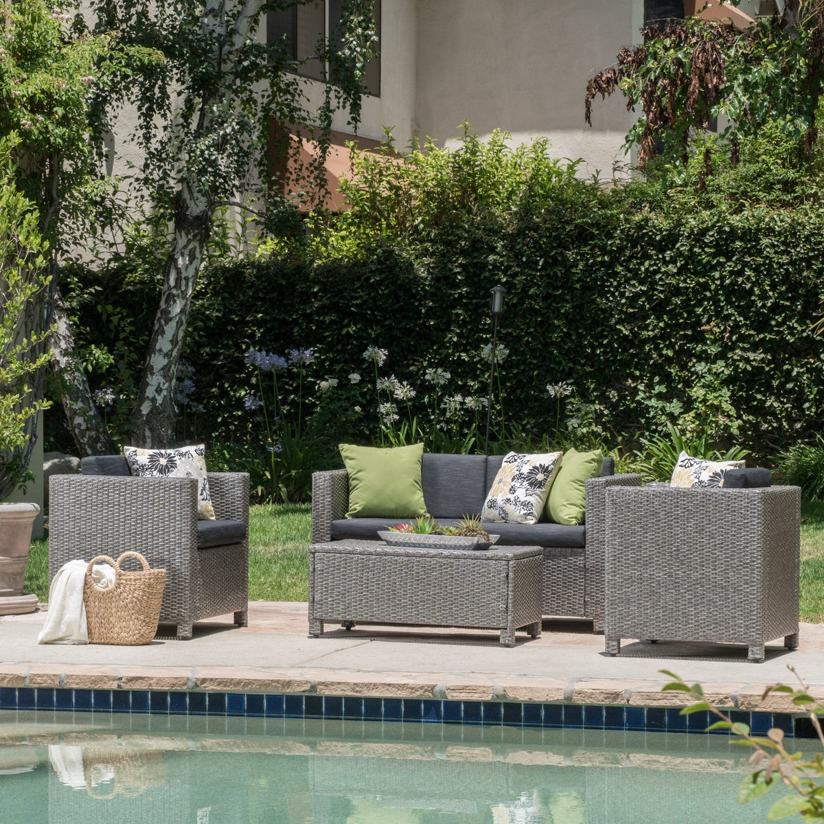 Puerta 4-Piece Outdoor Furniture Set gray wicker with green cushions on a poolside patio on Tampa Home & Garden Store