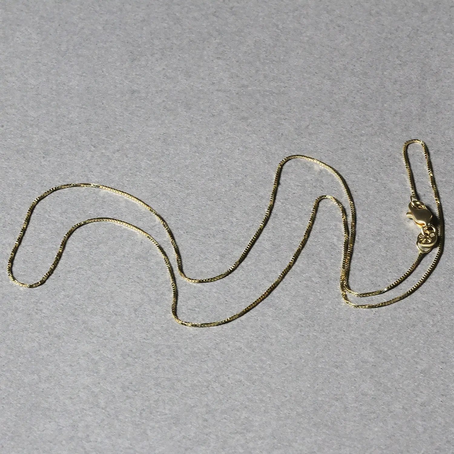 14k yellow gold box chain necklace 0.6mm by Bids.com with lobster clasp on gray background on Tampa Home & Garden Store