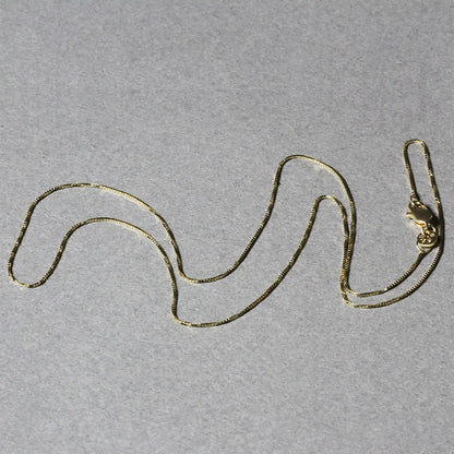 14k yellow gold box chain necklace 0.6mm by Bids.com with lobster clasp on gray background on Tampa Home & Garden Store