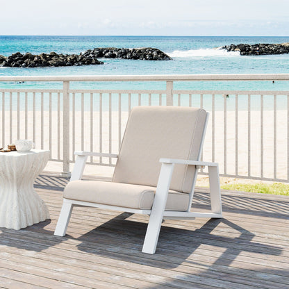 Outdoor patio lounge chair with beige cushion and white frame on a seaside deck on Tampa Home & Garden Store