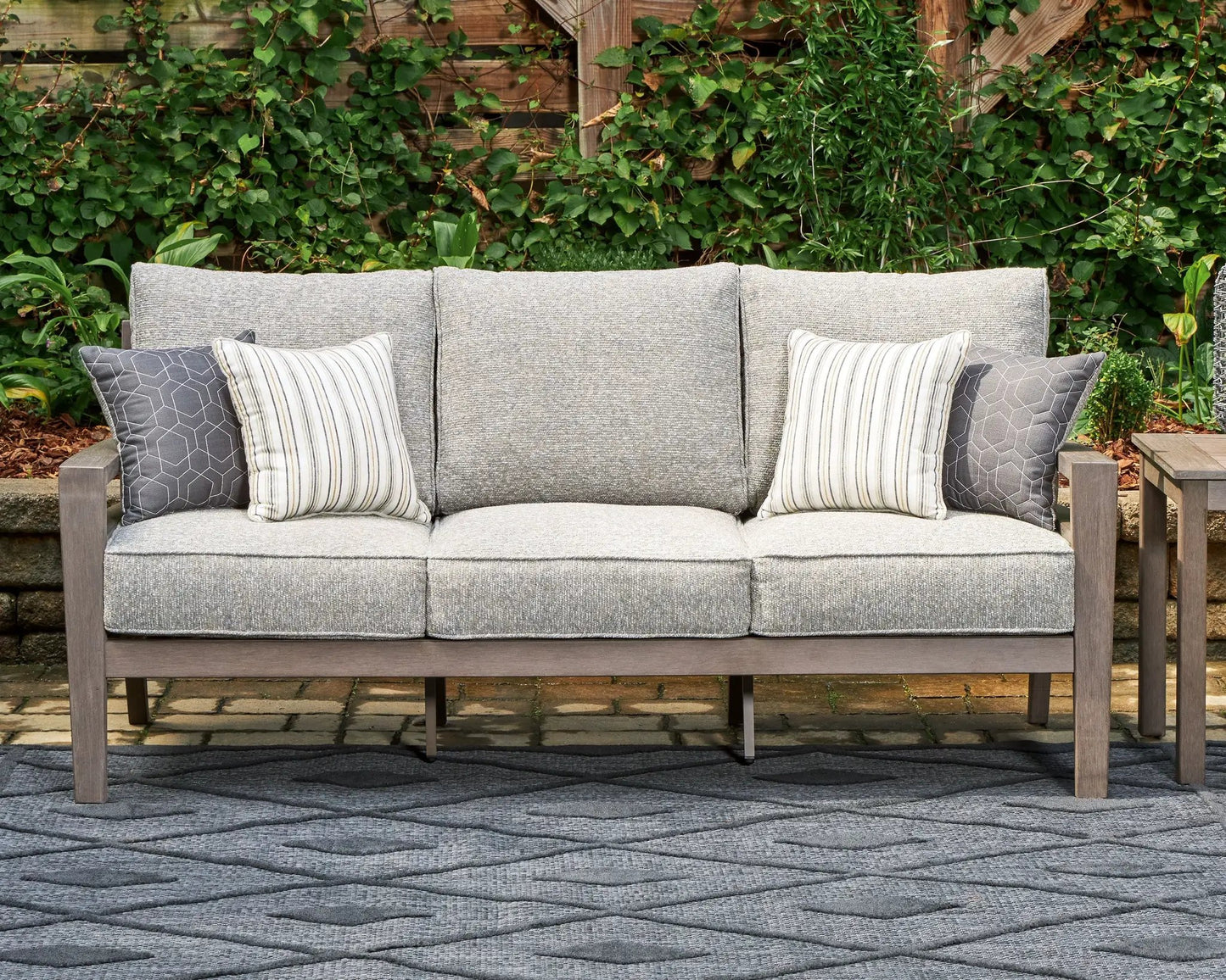 Hillside Barn sofa in gray textured fabric with brown wood frame and striped pillows on Tampa Home & Garden Store