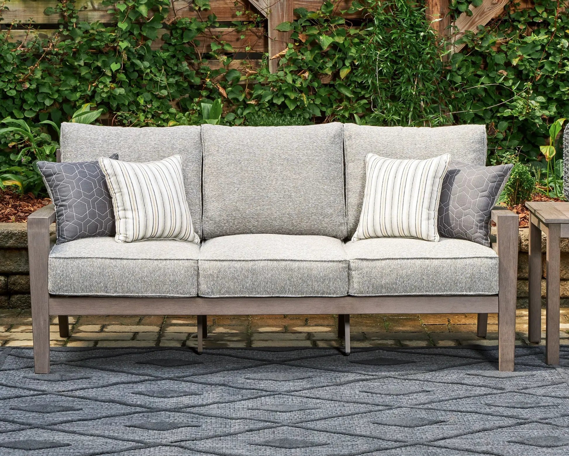 Hillside Barn sofa in gray textured fabric with brown wood frame and striped pillows on Tampa Home & Garden Store