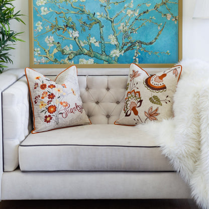 Thanksgiving embroidered floral throw pillows, two beige with orange piping on light sofa on Tampa Home & Garden Store