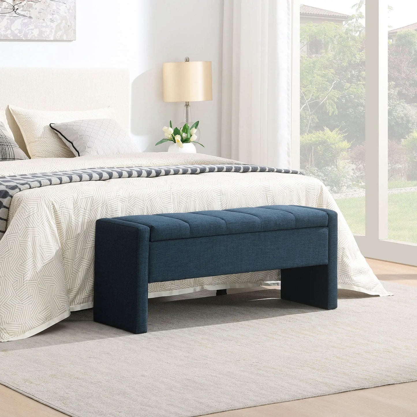 Modern upholstered bed end bench with storage in navy fabric at foot of bed with bedding on Tampa Home & Garden Store