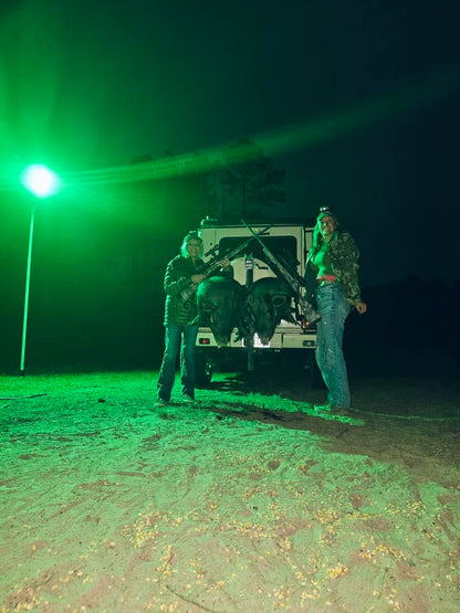 Green Langy Solar Lights hunting light, 15,000 lumens, outdoors at night with two hunters on Tampa Home & Garden Store