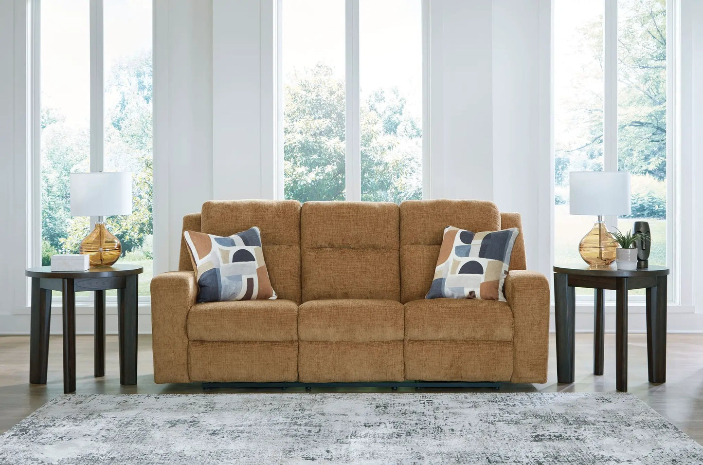Kanlow reclining sofa in warm caramel fabric with two geometric-pattern pillows on Tampa Home & Garden Store