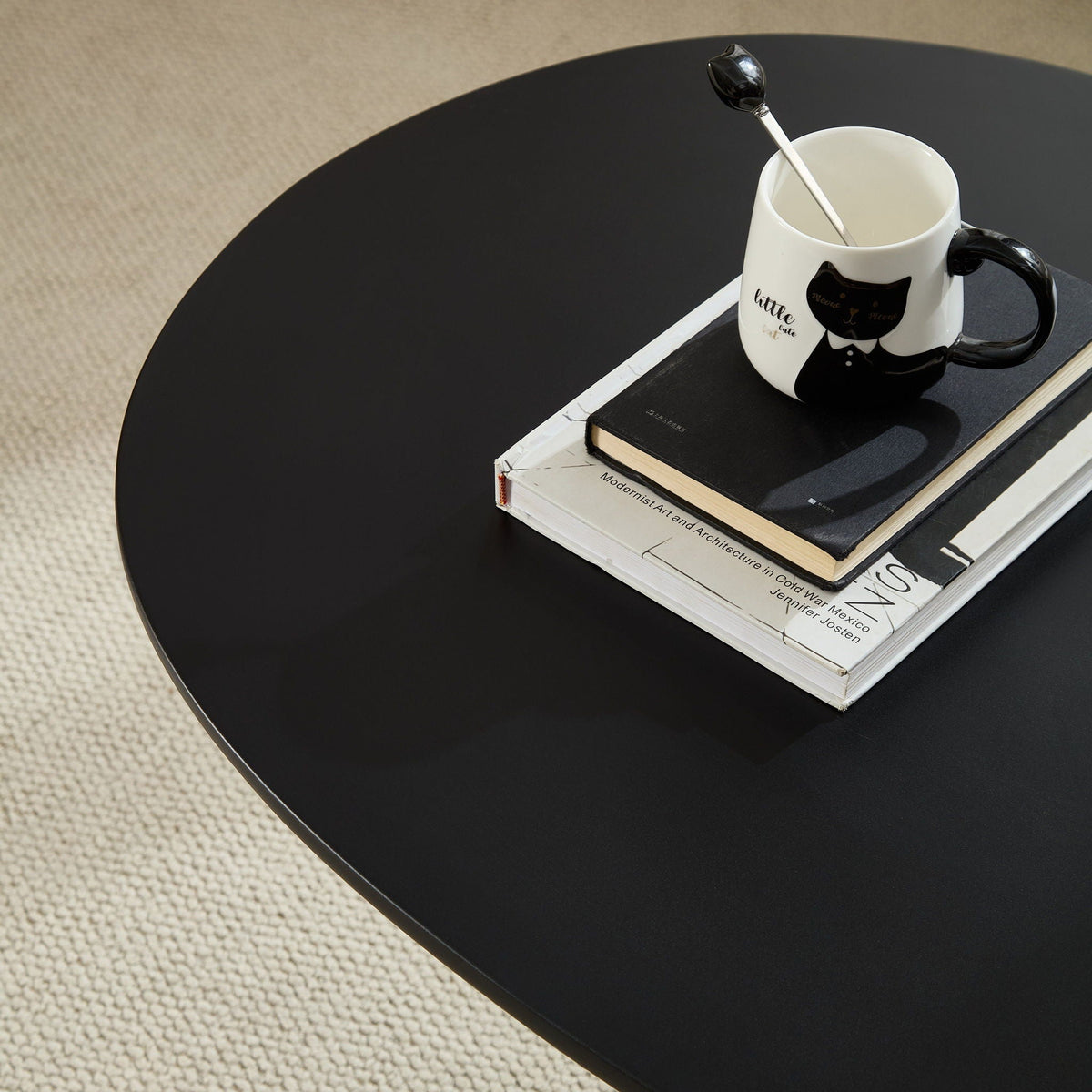Lucky Stone Shaped End Table with Sculptural Base, black finish, white cat mug and stacked books on Tampa Home & Garden Store