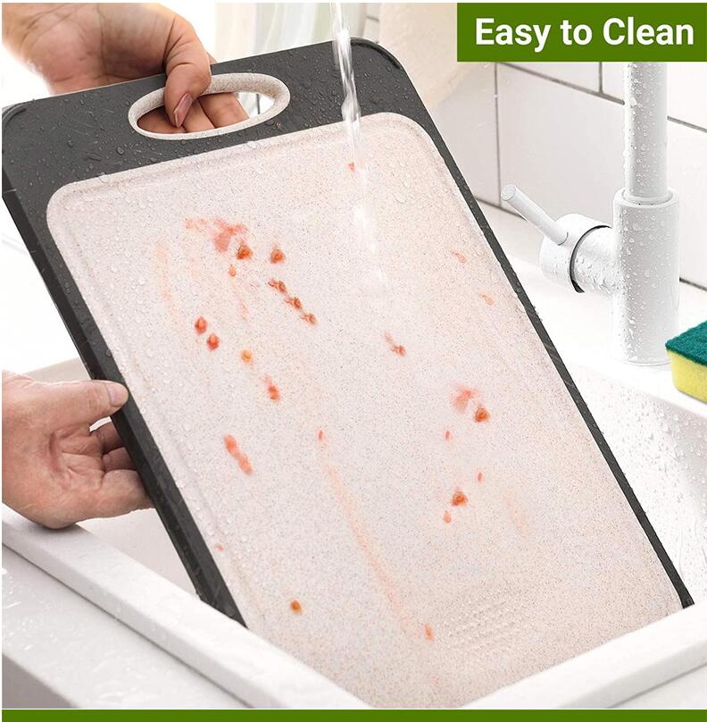 Two-sided plastic cutting board with black edge and pale pink surface rinsed under water on Tampa Home & Garden Store