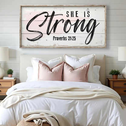 Canvas faith sign She Is Strong Proverbs 31:25 on distressed wood with black script, framed on Tampa Home & Garden Store