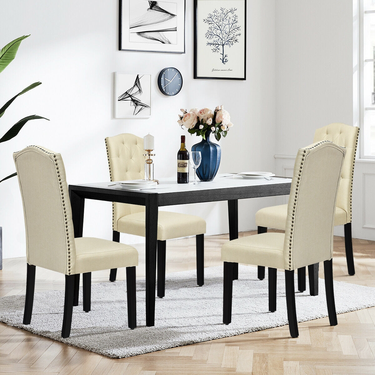 Dining room set with four cream upholstered chairs, nailhead trim, and a black rectangular table on Tampa Home & Garden Store