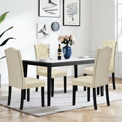 Dining room set with four cream upholstered chairs, nailhead trim, and a black rectangular table on Tampa Home & Garden Store