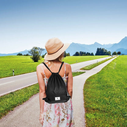 Drawstring backpack GemGear in black with zip pocket worn by woman on countryside road on Tampa Home & Garden Store