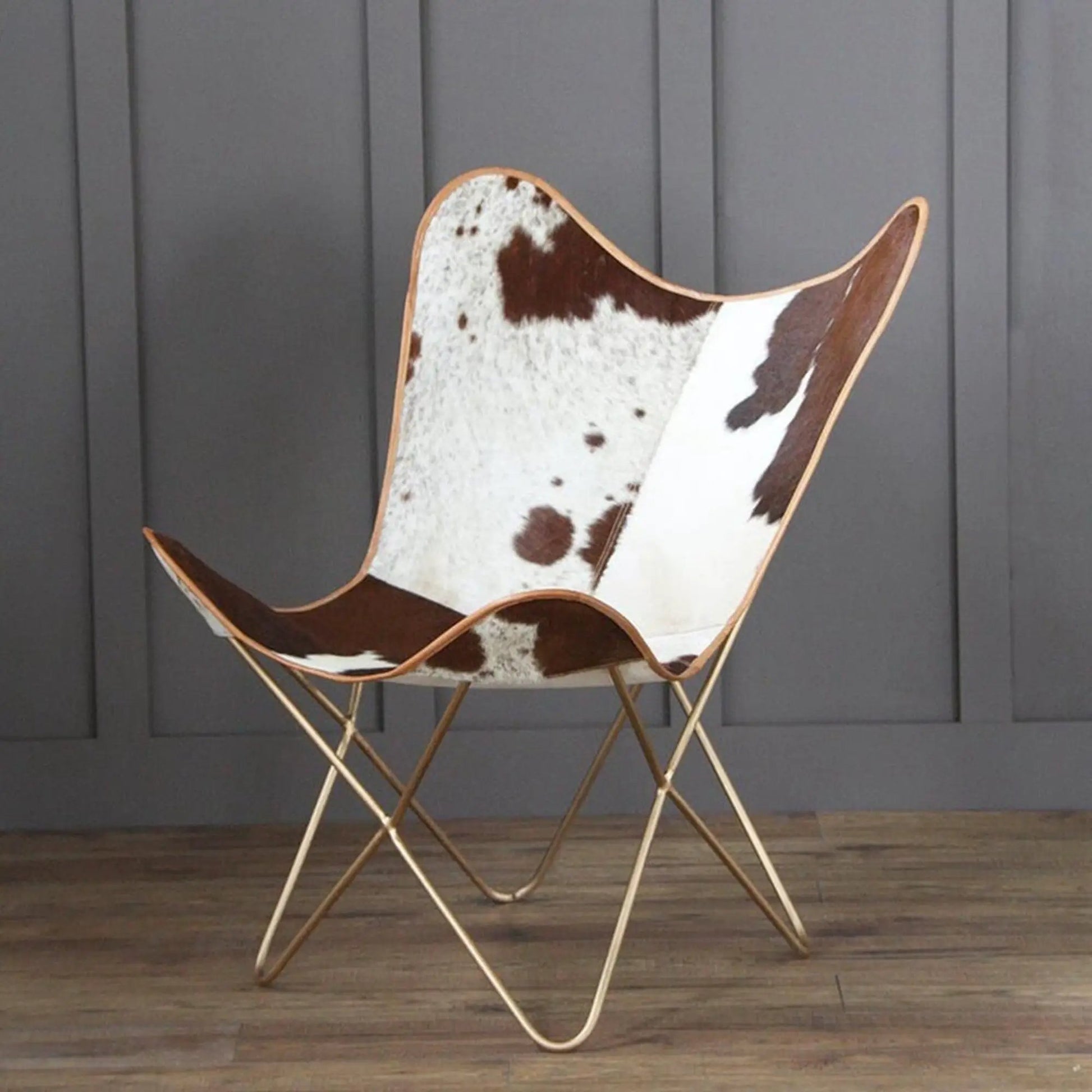 The Swiss Butterfly Chair with cowhide upholstery and gold-tone metal legs on Tampa Home & Garden Store