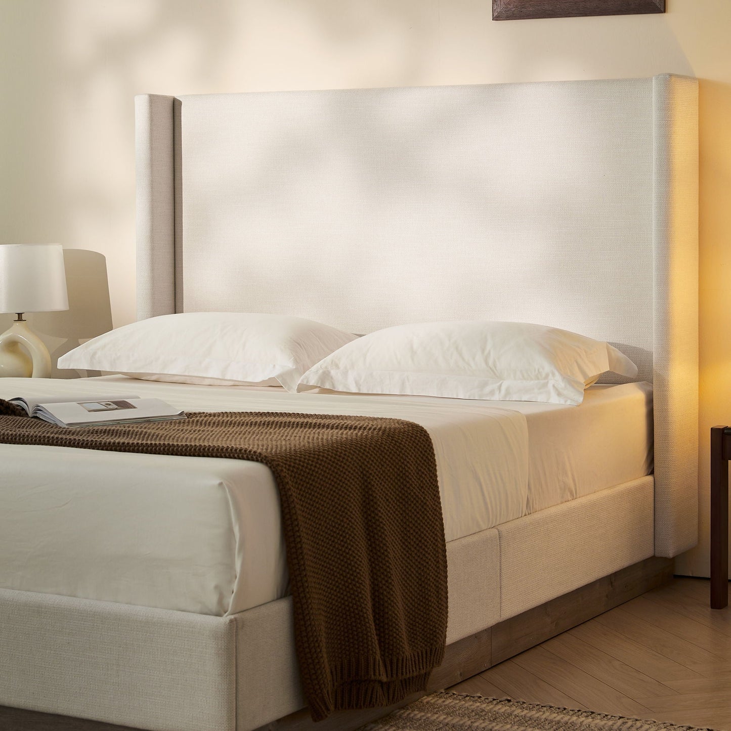 Hosford minimalist upholstered wingback bed in beige fabric with white bedding on Tampa Home & Garden Store