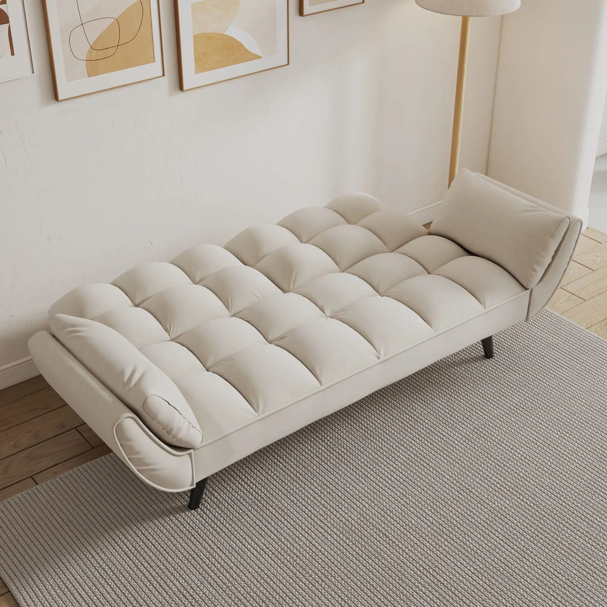 Futon sofa with tufted cream cushions and two padded armrests in a bright living room on Tampa Home & Garden Store