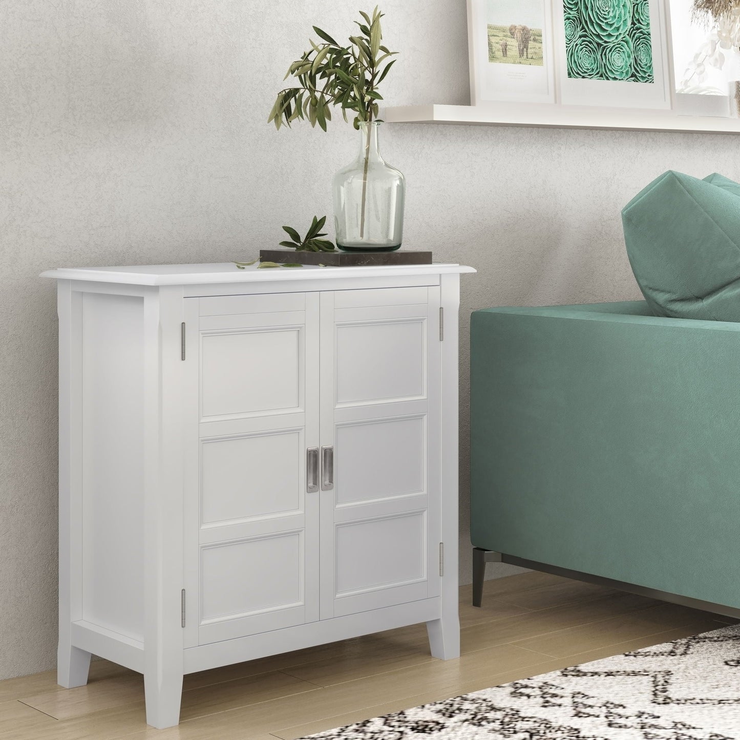 White Burlington handcrafted low storage cabinet with panel doors; metal handles, vase atop on Tampa Home & Garden Store