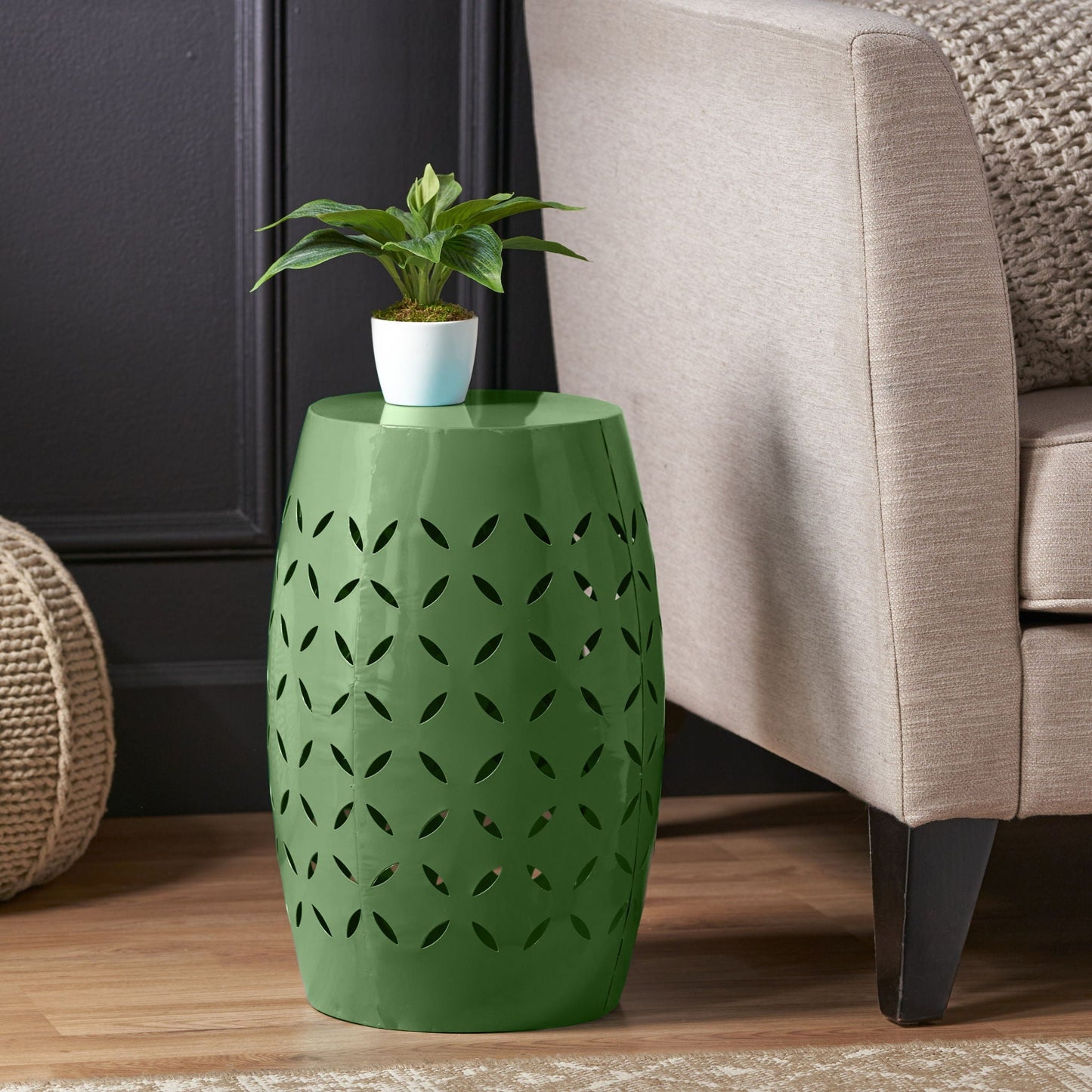 Barrel-shaped outdoor side table in green with leaf-cutout design, supporting a small plant on Tampa Home & Garden Store