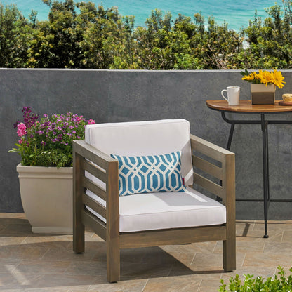 Outdoor Acacia Wood Patio Chair with white fabric cushion and blue geometric pillow, two armchairs on Tampa Home & Garden Store