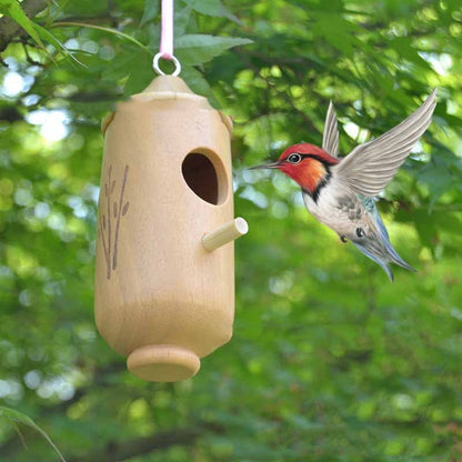 Wooden hummingbird nest house hanging from pink cord with a small perch, natural finish on Tampa Home & Garden Store