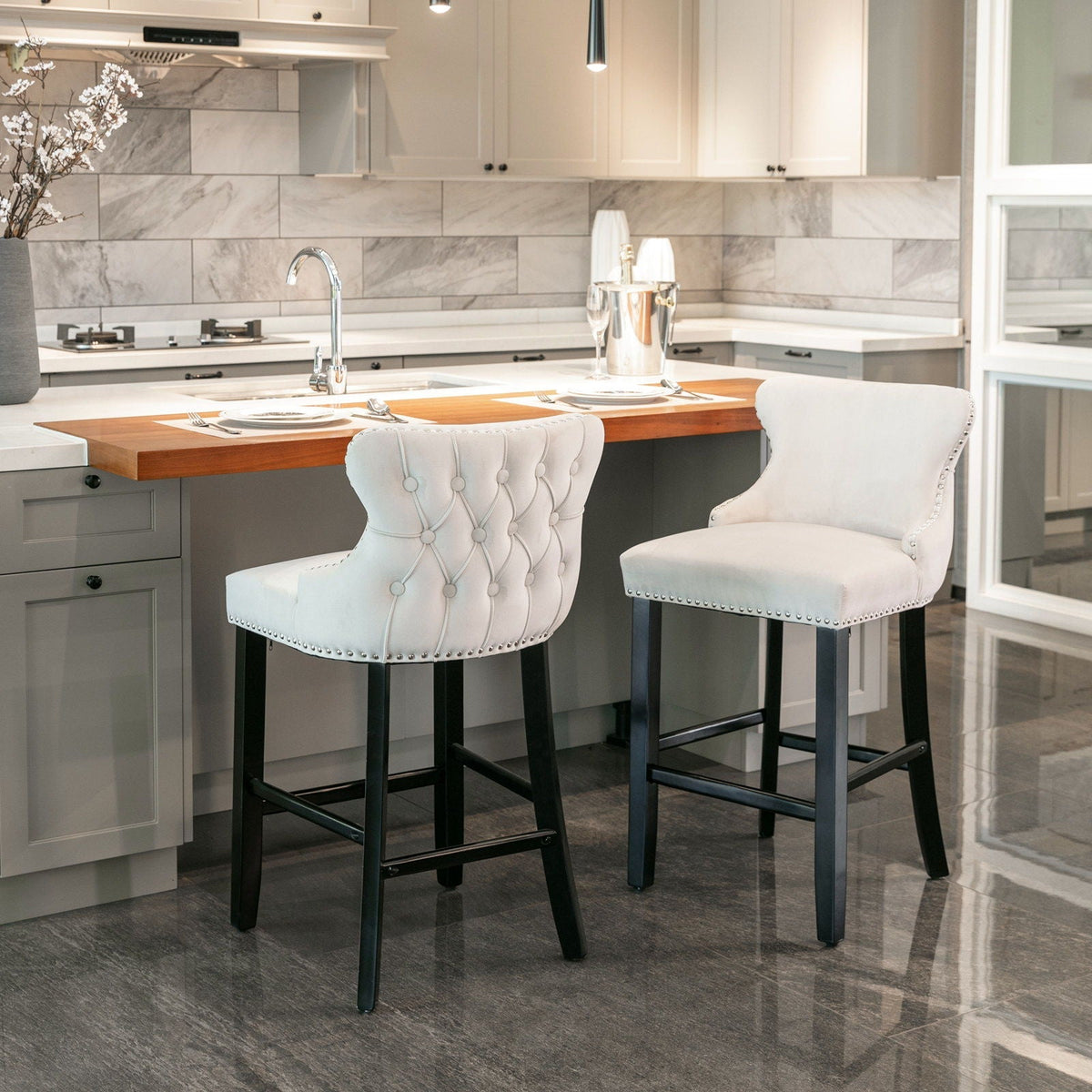 Upholstered wing-back barstools, white tufted fabric, nailhead trim, 2-pack at kitchen island on Tampa Home & Garden Store