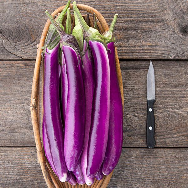 Ping Tung Long Eggplant seeds Seedtime Store; several glossy purple long eggplants in a wooden basket on Tampa Home & Garden Store