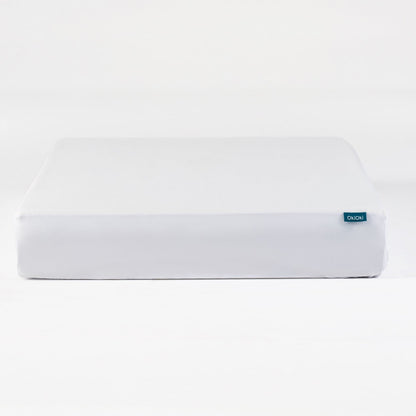 OkiOki Mattress Protector Queen, white fabric with blue OkiOki tag on edge on Tampa Home & Garden Store
