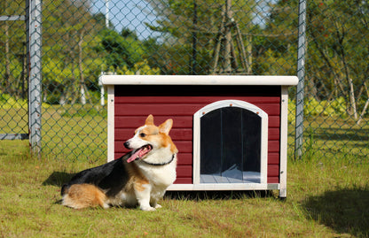 Medium wooden outdoor dog house red exterior with white trim and a dog beside it on lawn on Tampa Home & Garden Store
