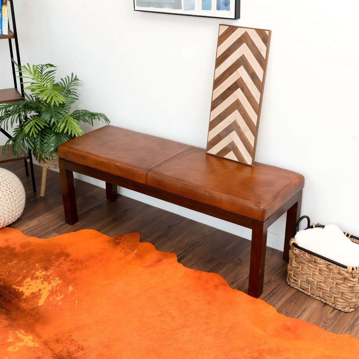 Antique brown upholstered bench with solid wood frame on floor beside chevron panel and plant on Tampa Home & Garden Store
