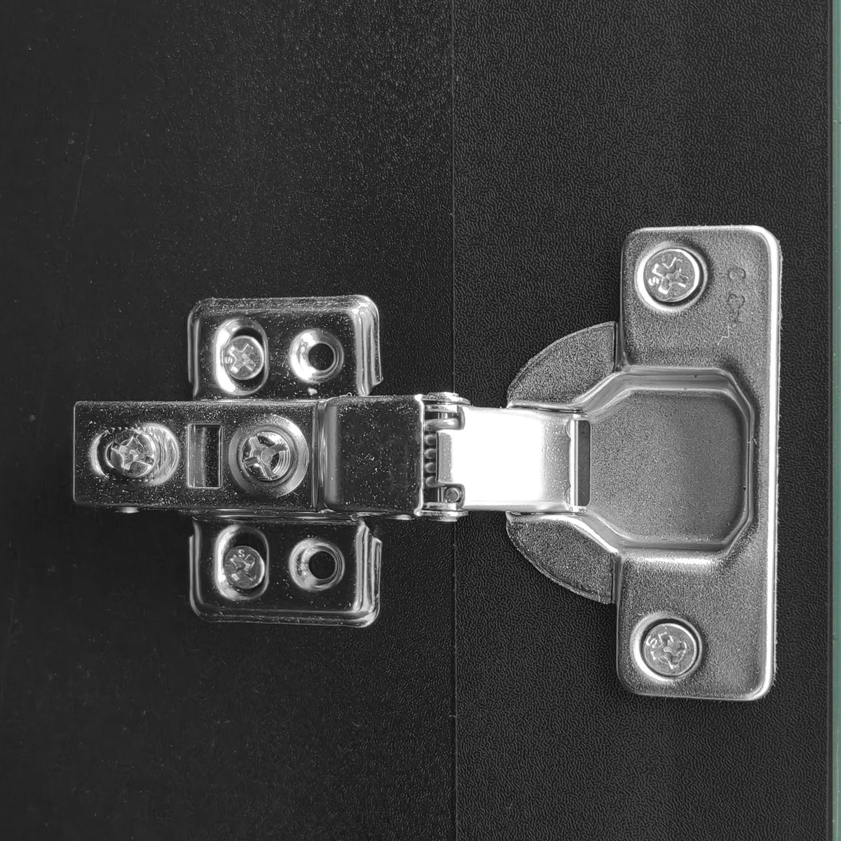 Entertainment center hardware close-up with silver brackets and screws on black textured surface on Tampa Home & Garden Store
