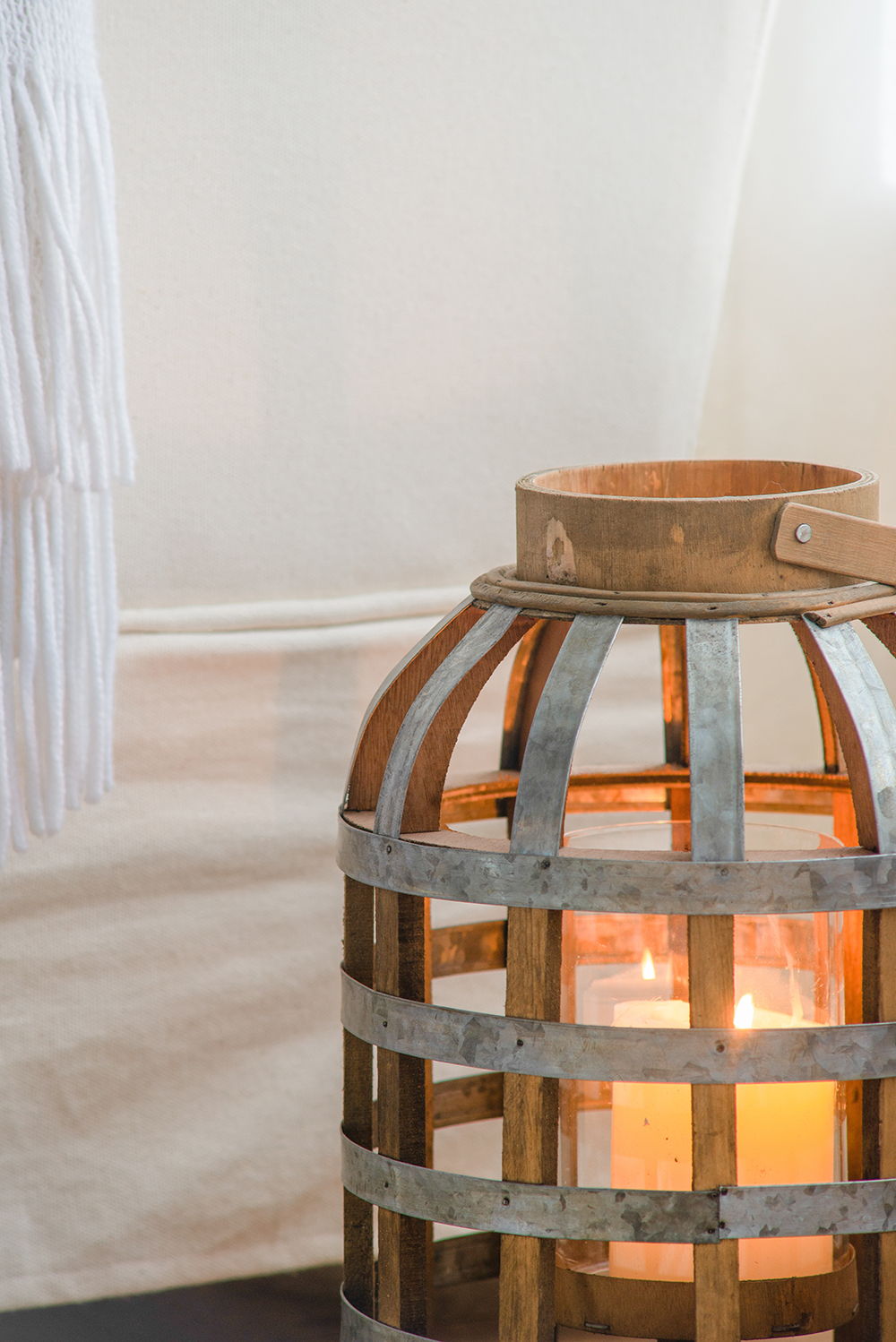 Decorative wooden lantern with metal bands and carrying handle, candlelit indoors on Tampa Home & Garden Store