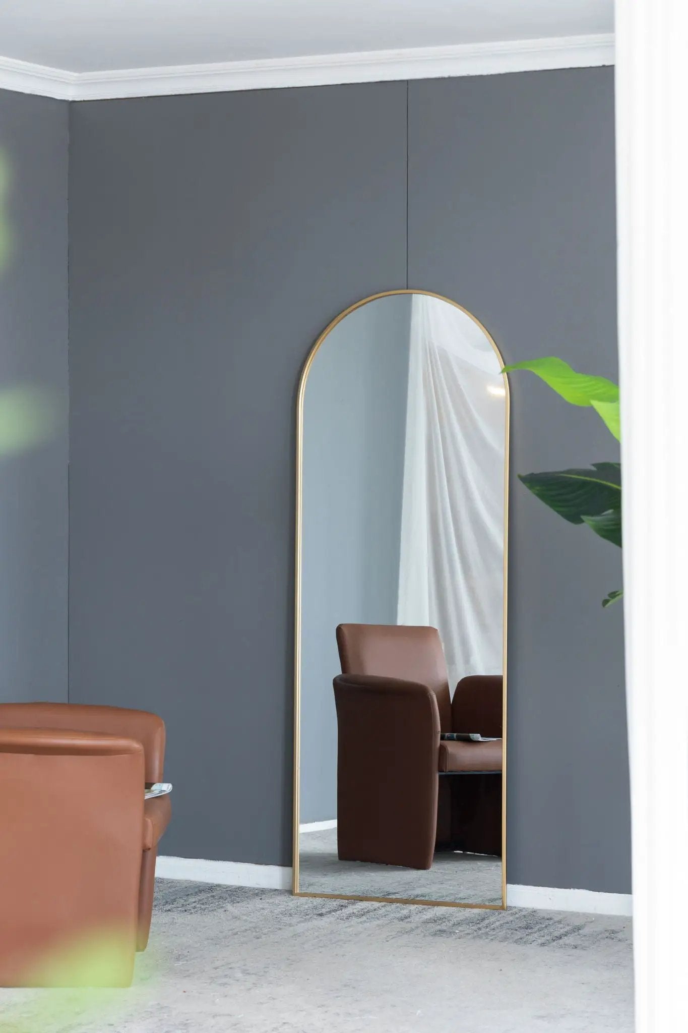 Celine Arch Body Mirror gold frame floor mirror in gray room reflecting brown seating on Tampa Home & Garden Store