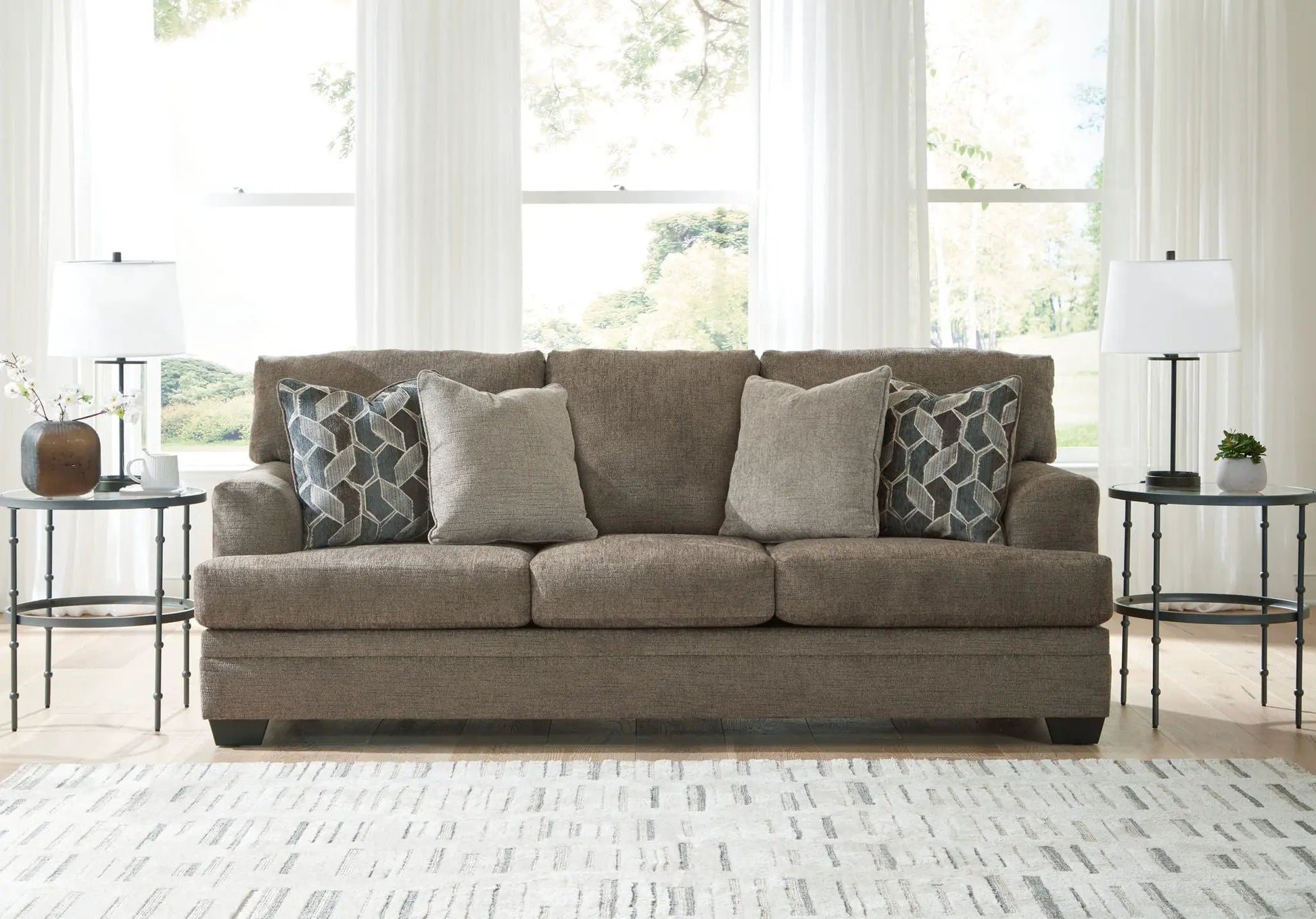 Stonemeade Living Room Set taupe sofa with geometric pillows, flanked by end tables and lamps on Tampa Home & Garden Store